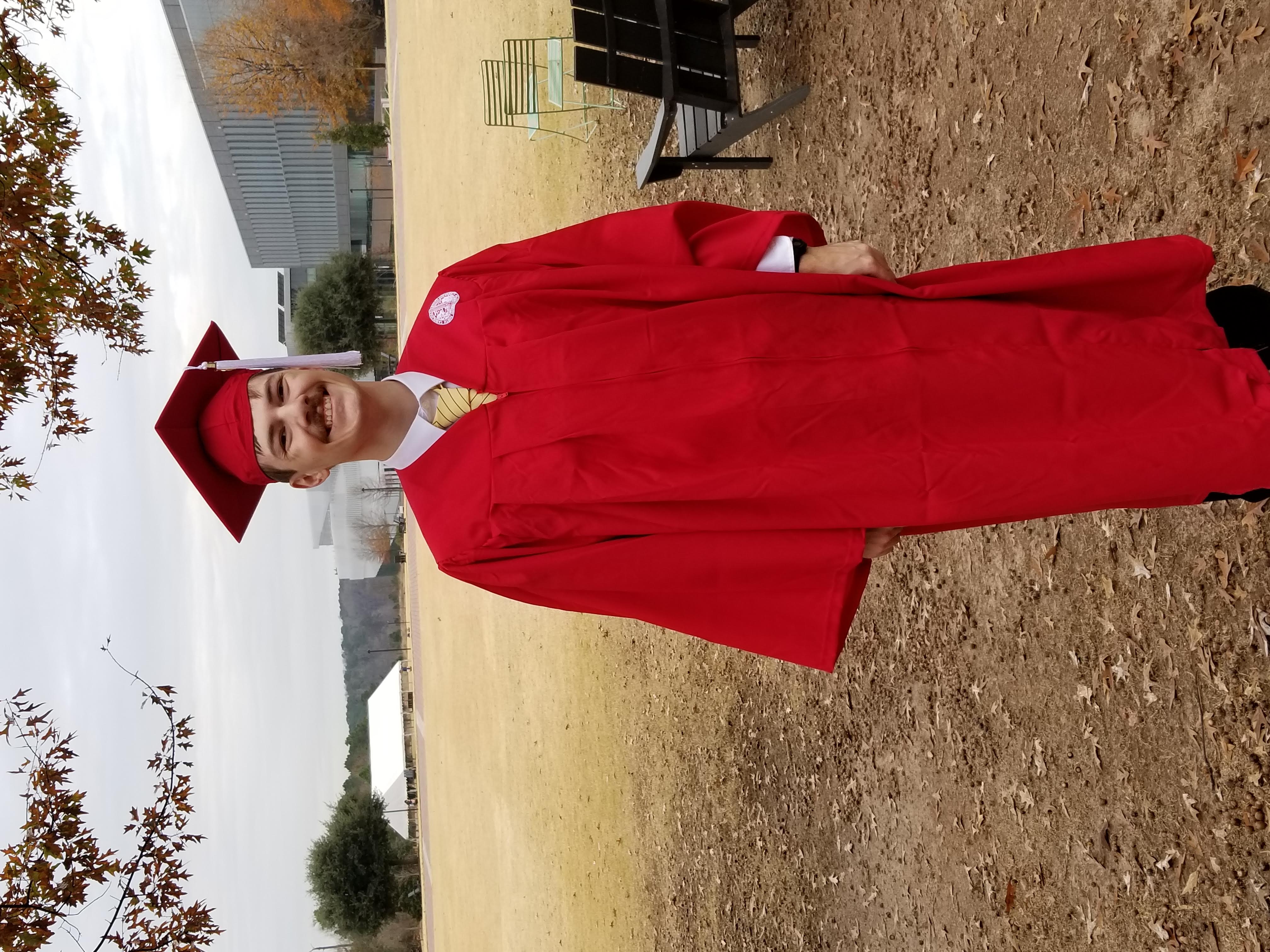 A picture of Michael after graduating with hunt library visible in the background